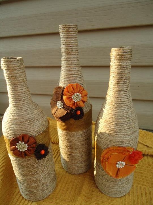 Wine bottles are wrapped with twine and decorated with plastic flowers