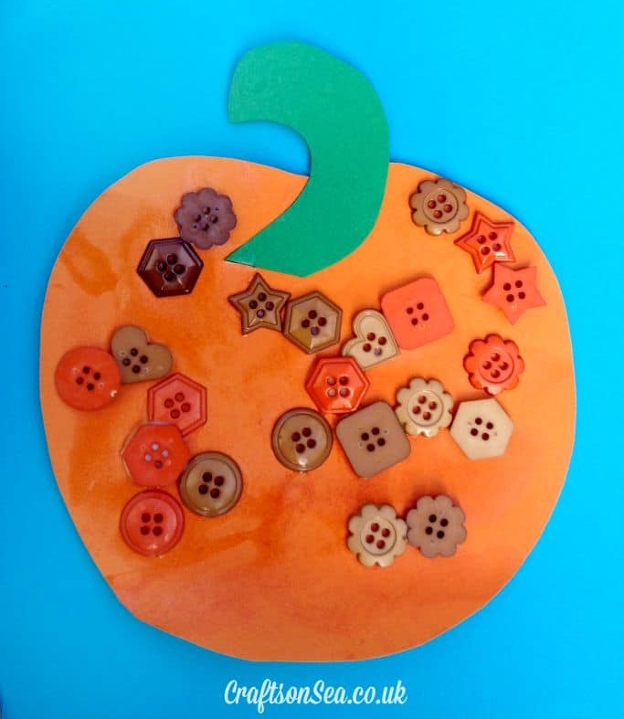 Orange paper pumpkin with buttons glued all over it