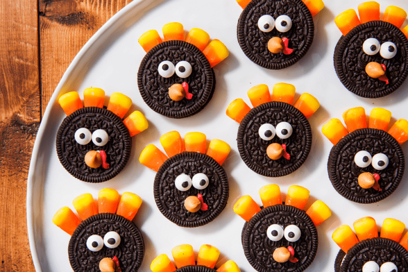 A platter holds Oreo cookies with candy corn feathers and edible candy eyes and beaks