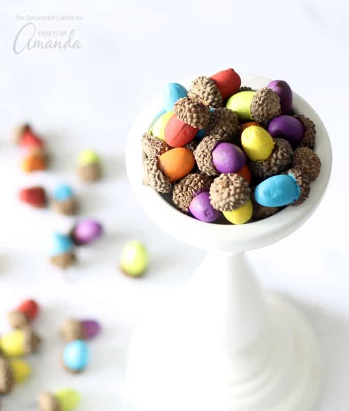 Colorful painted acorns sitting in a dish