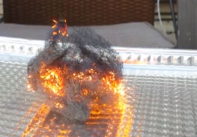 Steel wool sitting in an aluminum tray. The steel wool appears to be on fire in this example of 6th grade science fair projects