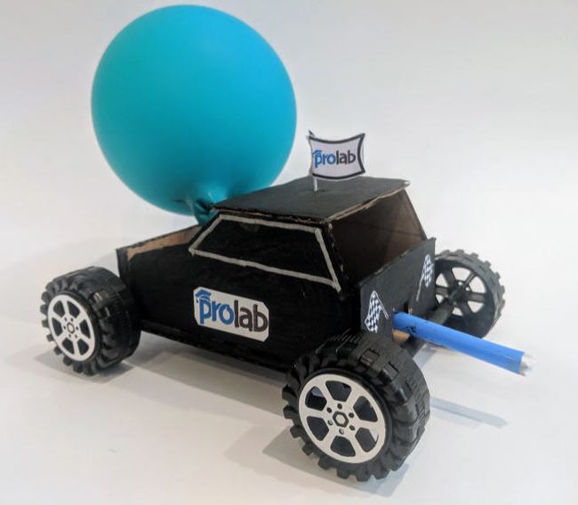 Car made from cardboard with bottlecap wheels and powered by a blue balloon (easy science experiments)