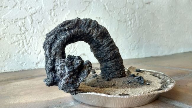 Large carbon ash snake growing out of a pan of sand in this example of 6th grade science fair projects