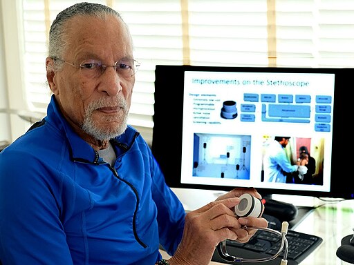 Photo of inventor James West sitting at a computer in his office