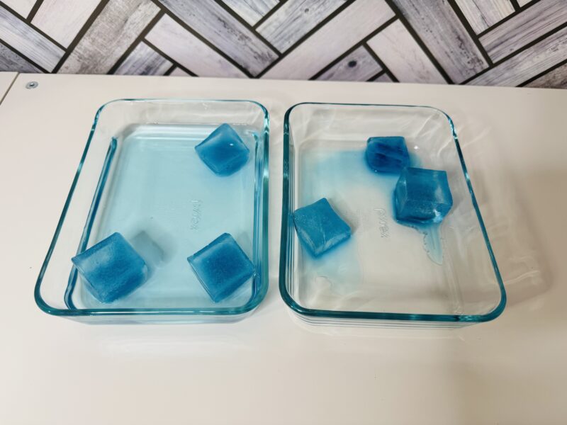 Blue ice cubes in a divided container, with the left side also containing water (Climate Change Activities)