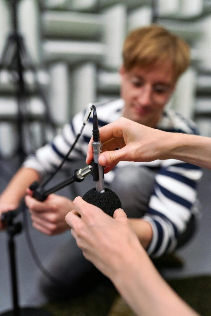 A person's hands are seen adjusting a microphone.