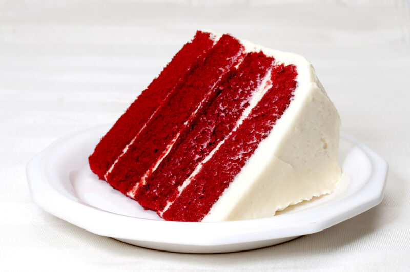 Slice of red velvet cake on a place as an example of the tradition of eating red foods on Juneteenth.