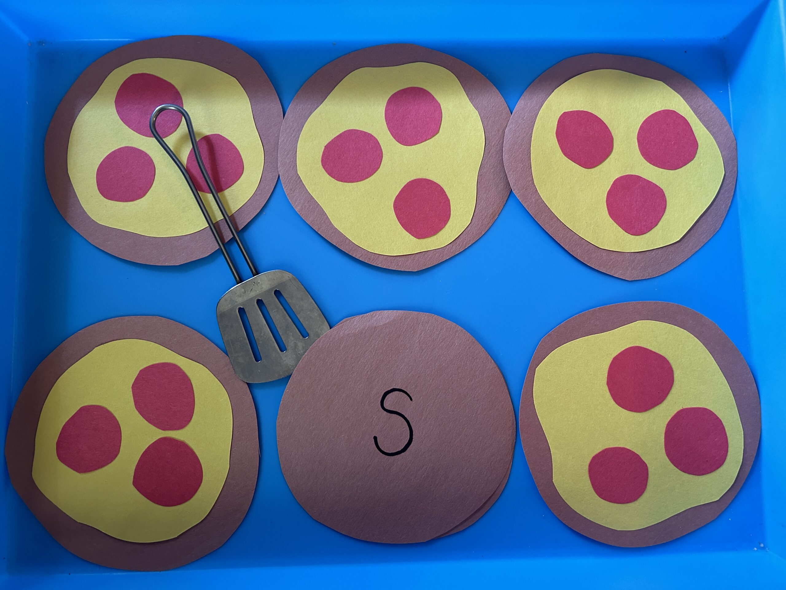 Flip the pizza made of construction paper as an example of phonics activities.