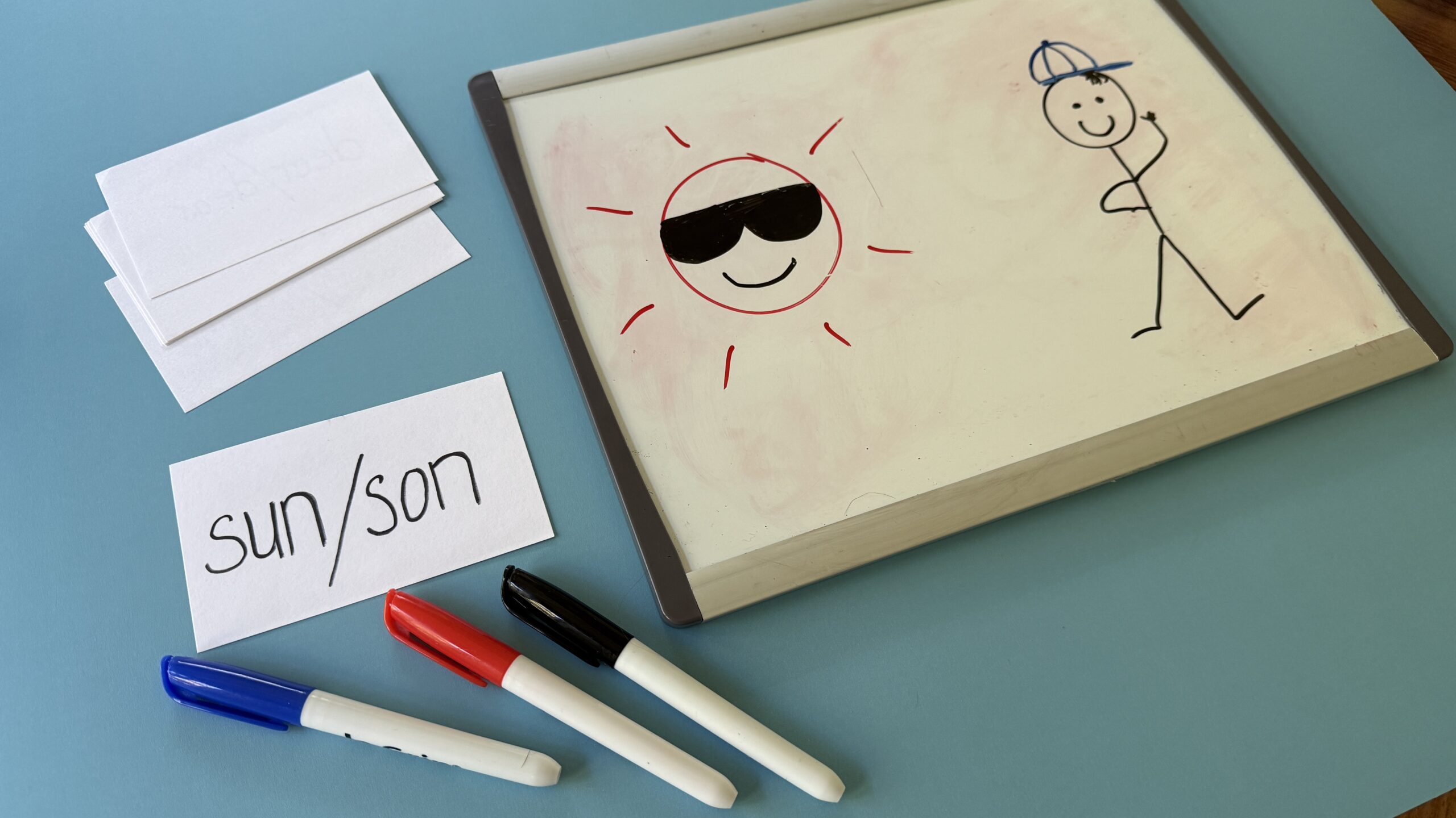 Homophone Pictionary with notepad of drawing of sun and stick figure Homophone Pictionary with notepad of drawing of sun and stick figure