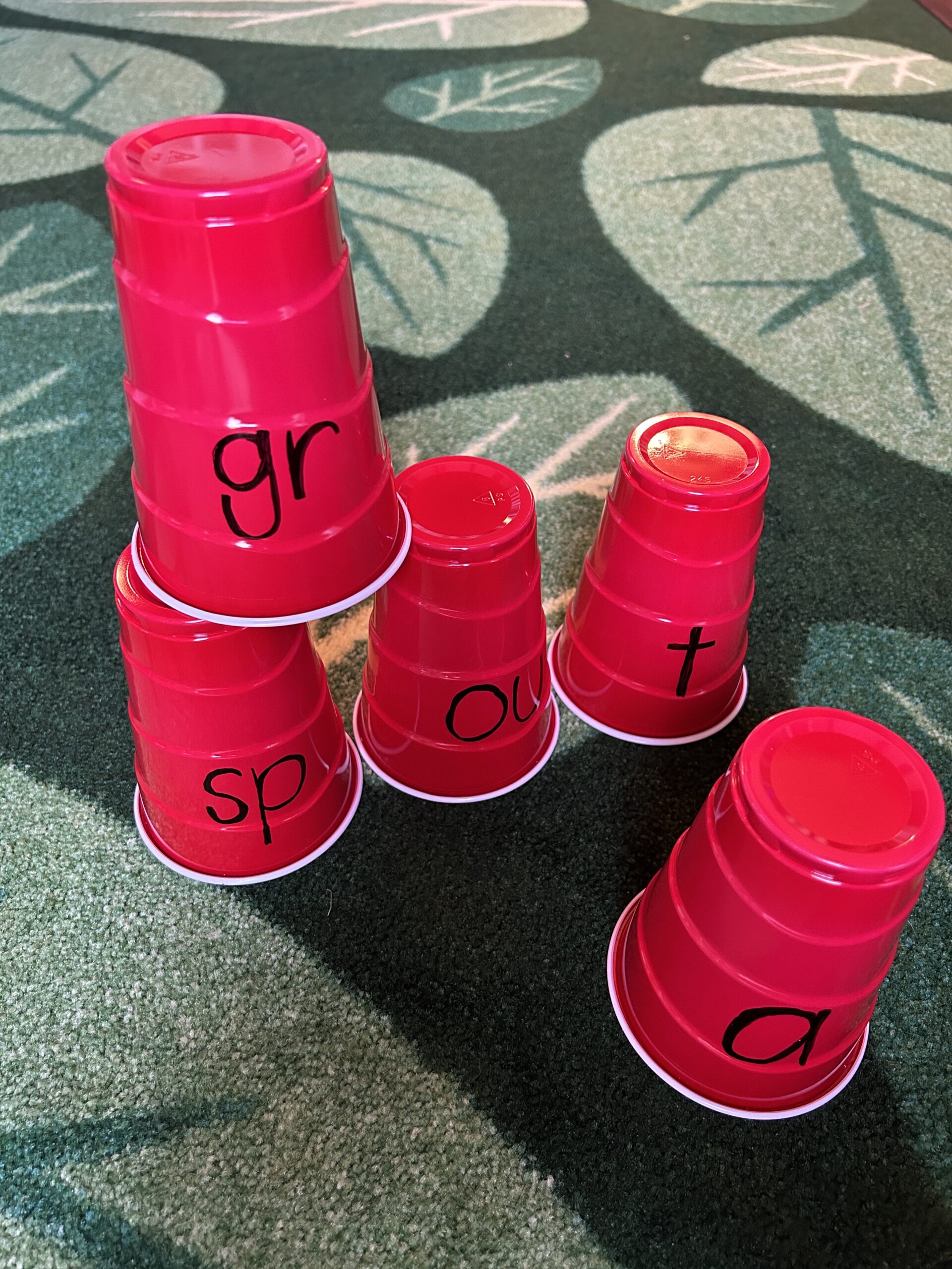 Mix and match red plastic cups to make words as an example of phonics activities