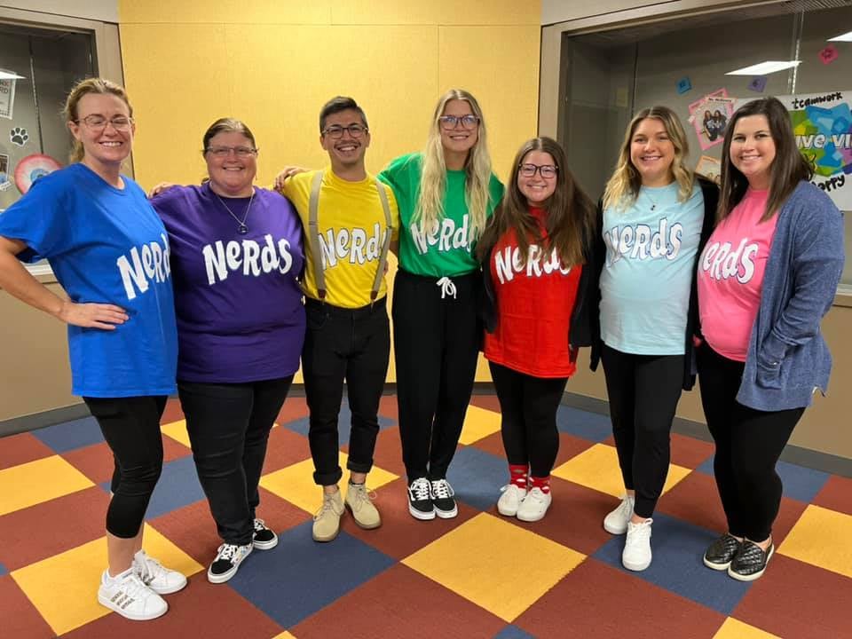 Group of teachers dressed in colorful t-shirts with the Nerds candy logo