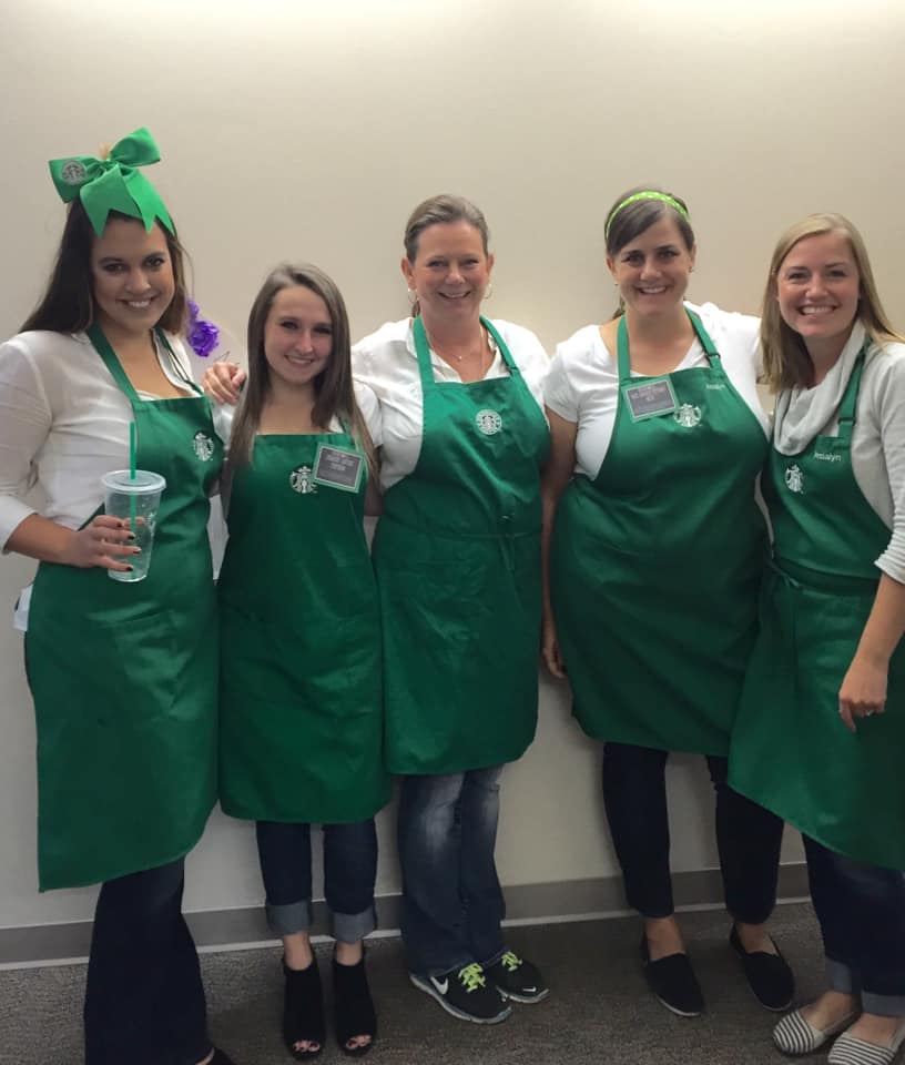 Teachers dressed as Starbucks baristas in green aprons