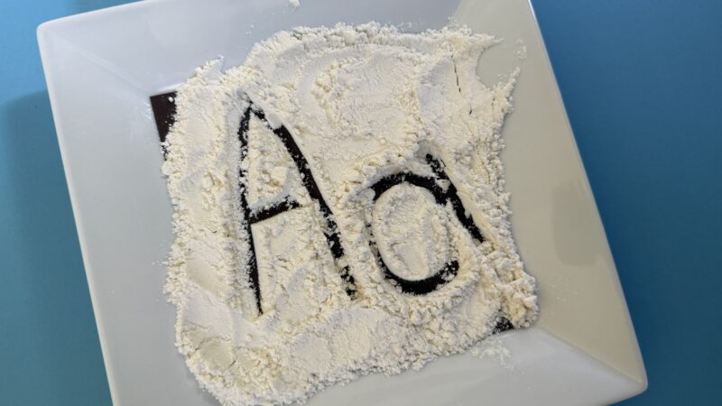 letters traced in flour on table