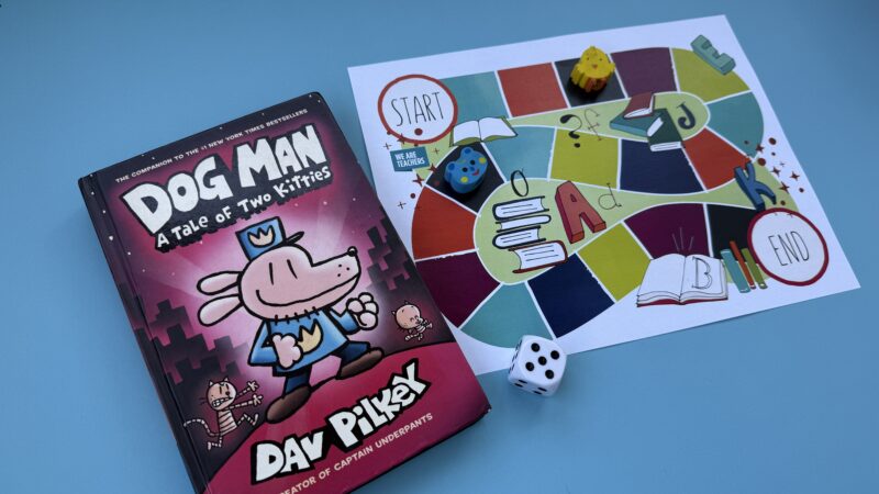 Colorful board game next to book